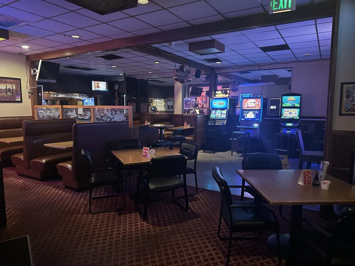 Restaurant interior with slot machines, dining tables, and booth seating at Lee's Kitchen，a Chinese Restaurant in Tualatin