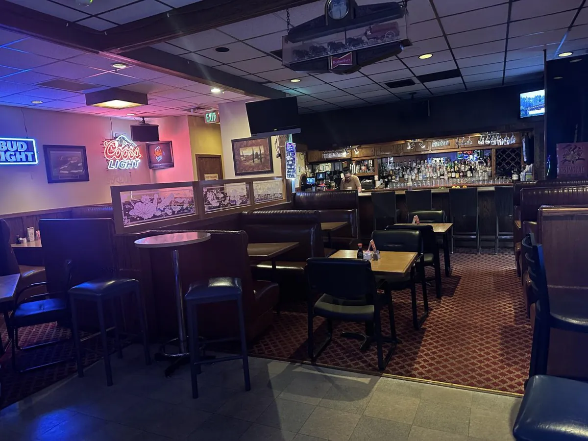 Restaurant bar with a full liquor shelf, booth seating, and neon beer signs at Lee's Kitchen，a Chinese Restaurant in Tualatin